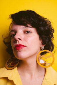 mulher branca de cabelo curto em fundo amarelo