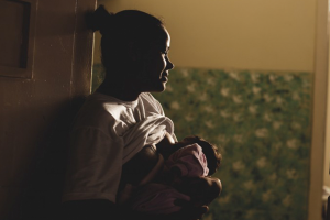Foto do livro Mães do cárcere mostra mãe amamentando criança