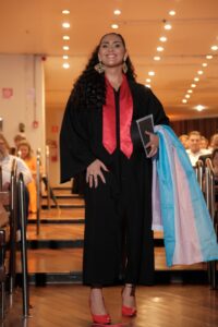 mulher com beca de formatura e sorrindo