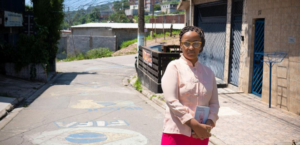 Foto mostra Lilia Guerra segurando seu livro "O céu para os bastardos"