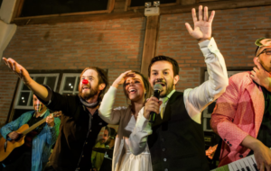 Foto do casamento de Priscilla e Fernando, que se conheceram por causa do carnaval, mostra a banda Estrambelhados cantando no casamento