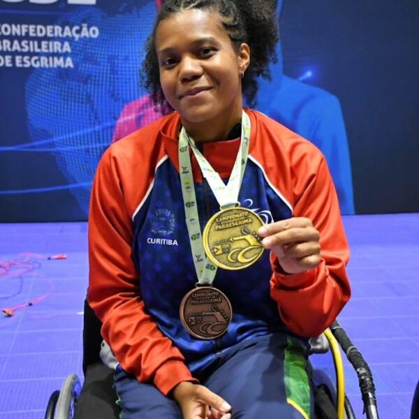 mulher em cadeira de rodas segura medalha