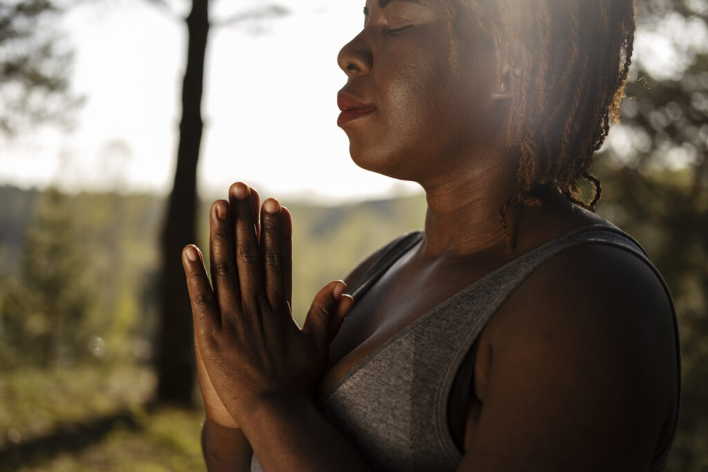 mulher negra com mãos unidas em oração