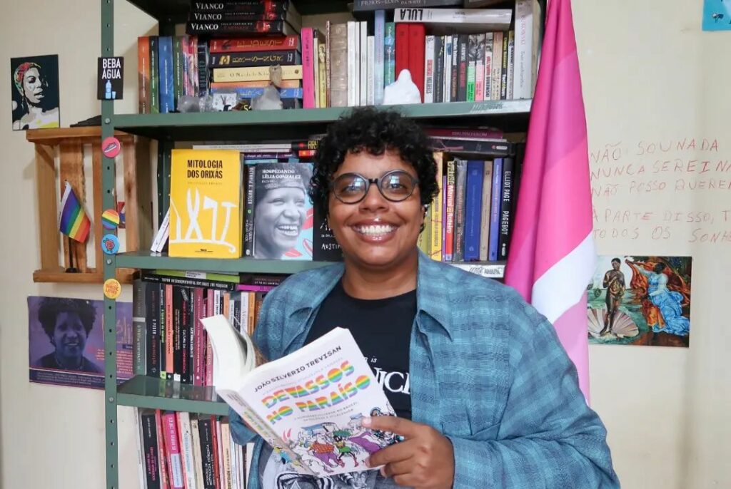 mulher negra a frente de estante de livros