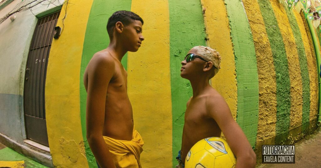 Foto de crianças. Dois meninos em frente a parede verde e amarela