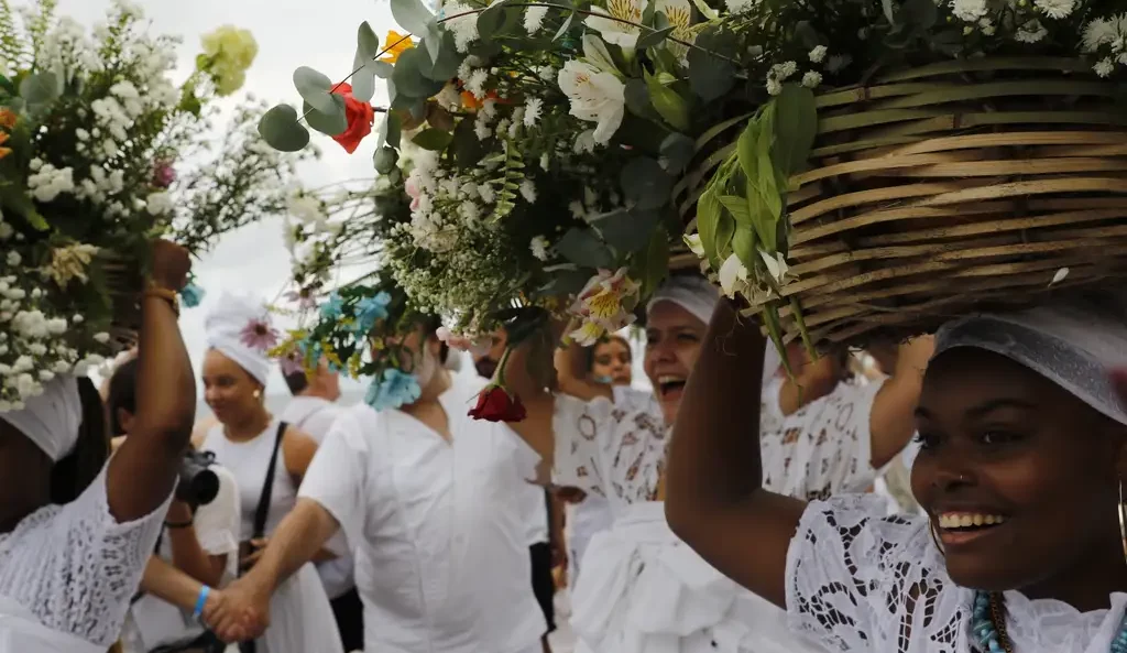 mulheres de branco seguram flores