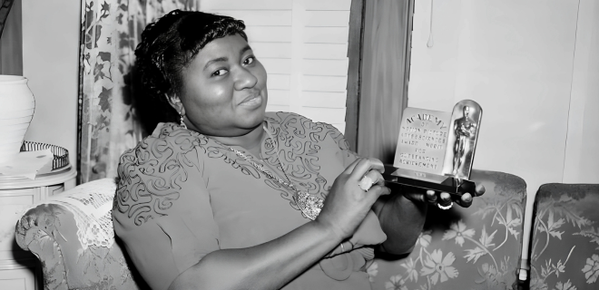 Foto em preto e branco mostra Hattie McDaniel segurando seu Oscar