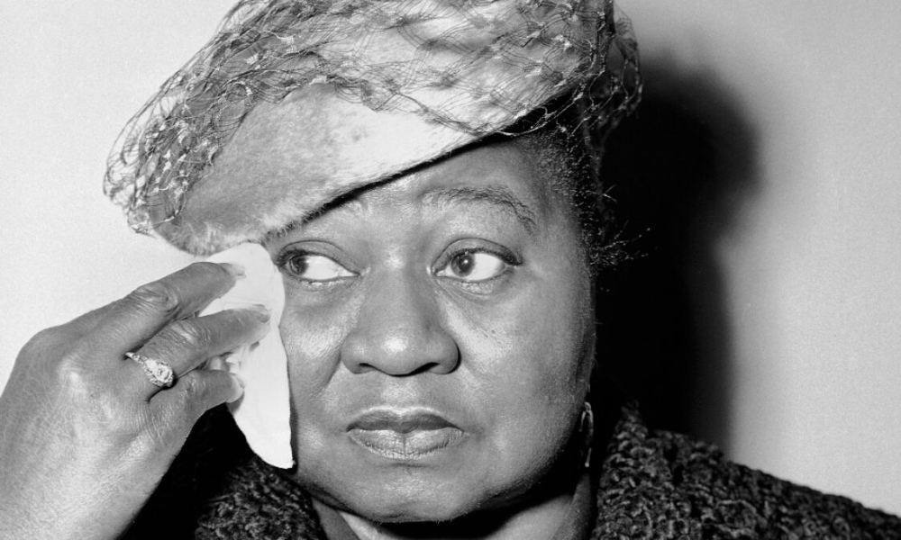 Foto em preto e branco mostra Hattie McDaniel limpando o rosto com um lenço