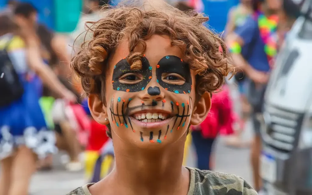 criança com rosto pintado no carnaval