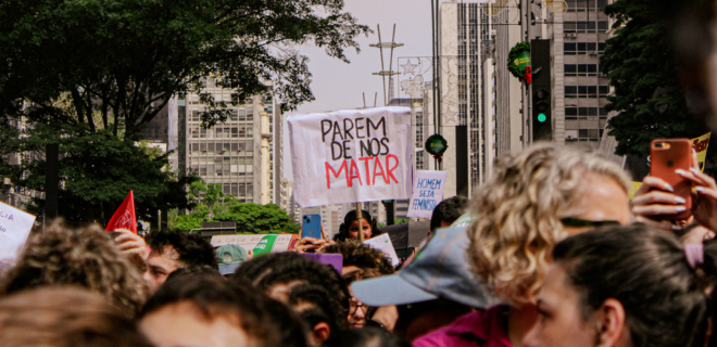 Foto de marcha contra o feminicídio mostra mulher segurando um cartaz escrito parem de nos matar