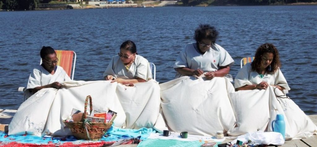 mulheres da coletiva tear e poesia bordando sobre um rio