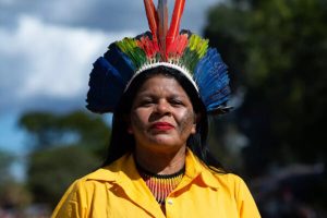 mulher indígena usa cocar 