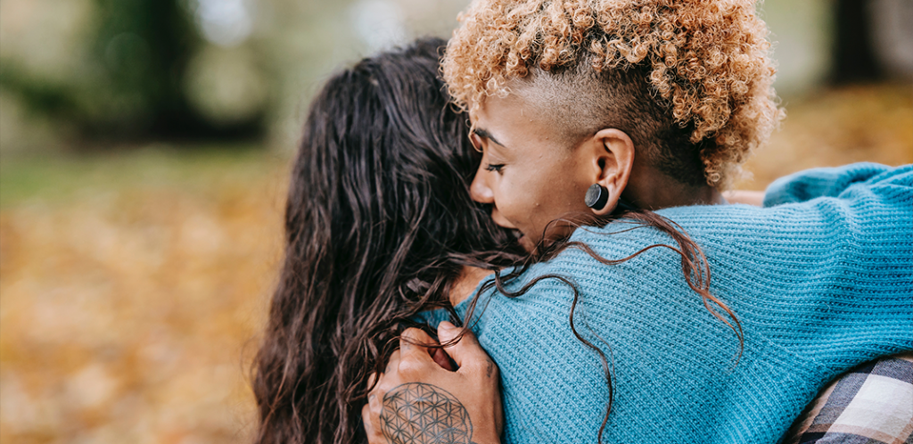 Foto mostra duas mulheres se abraçando representando o amor entre pessoas psicoatípicas