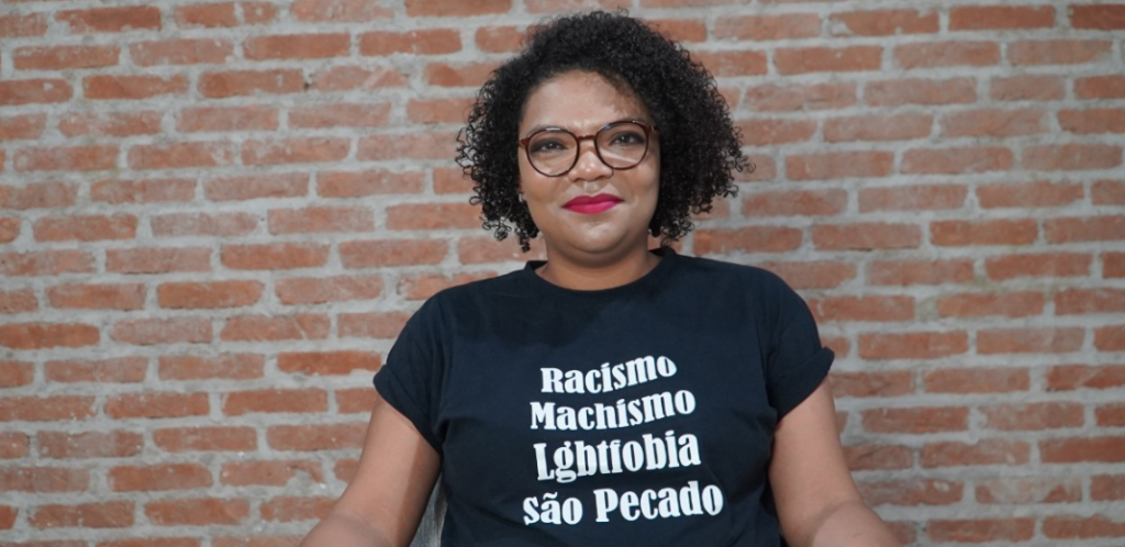 Mulher negra com camiseta escrito: racismo, machismo lgbtfobia são pecado