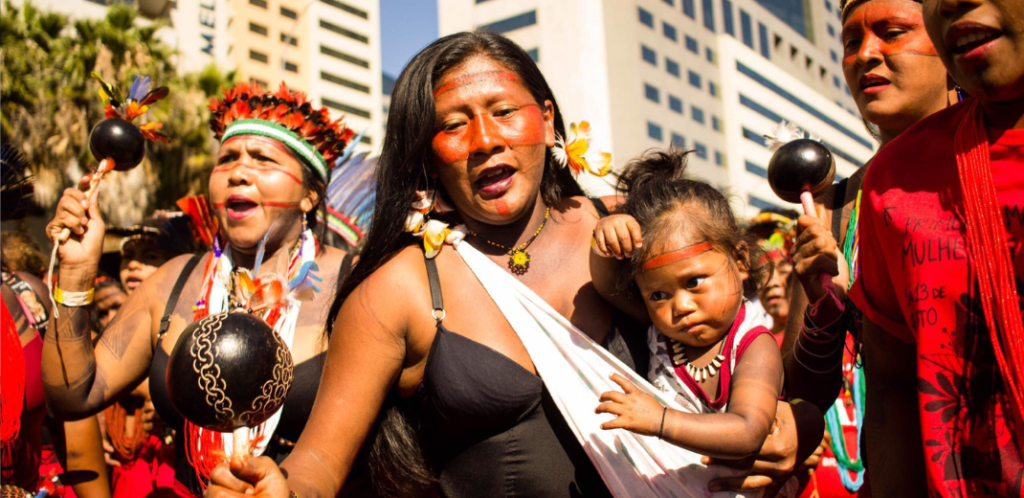 Foto mostra mulher indígena com seu bebê em manifestação