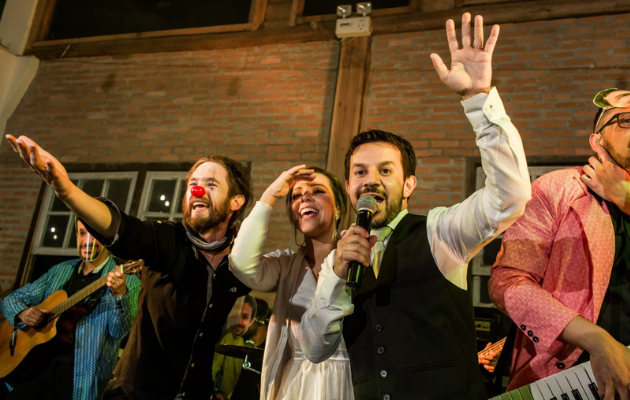 Foto do casamento de Priscilla e Fernando, que se conheceram por causa do carnaval, mostra a banda Estrambelhados cantando no casamento